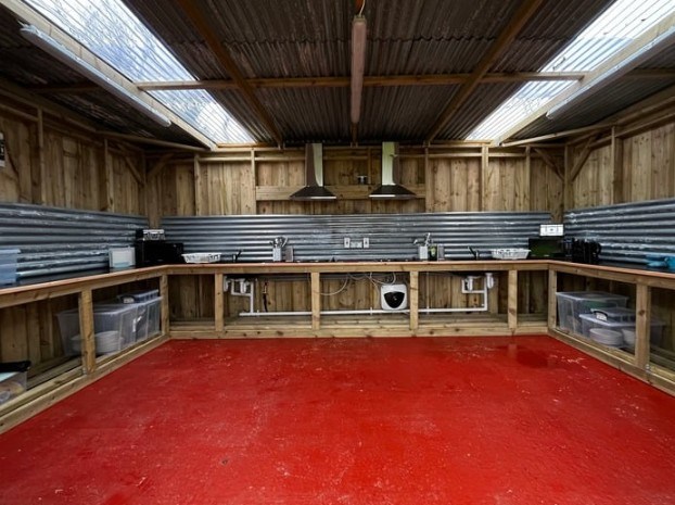 Large, wooden kitchen with red floor, metal backsplash, and skylights